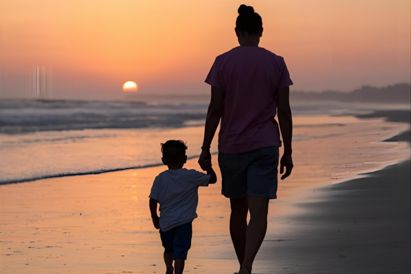 A mother and child are walking on the beach as the sun sets. The image represents the course Parenting Autism